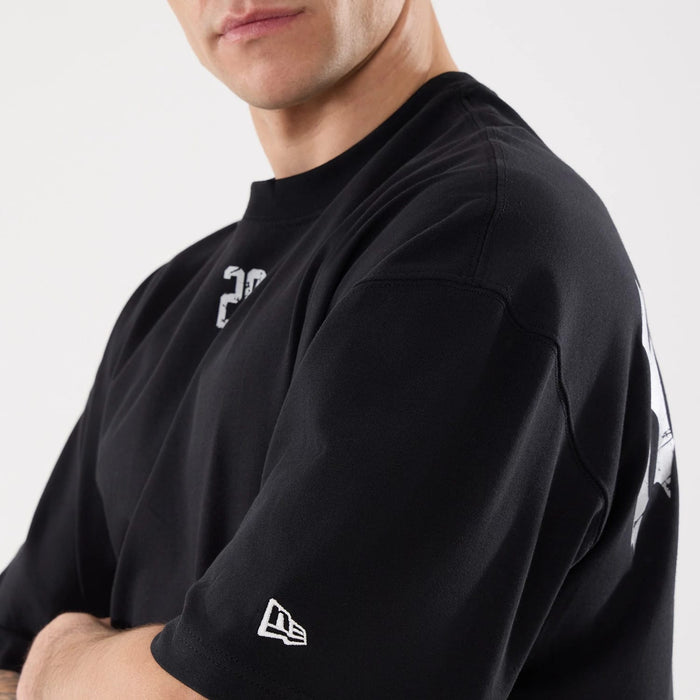 The model is wearing this New Era Street Archived City Oversized T-Shirt in black. 5